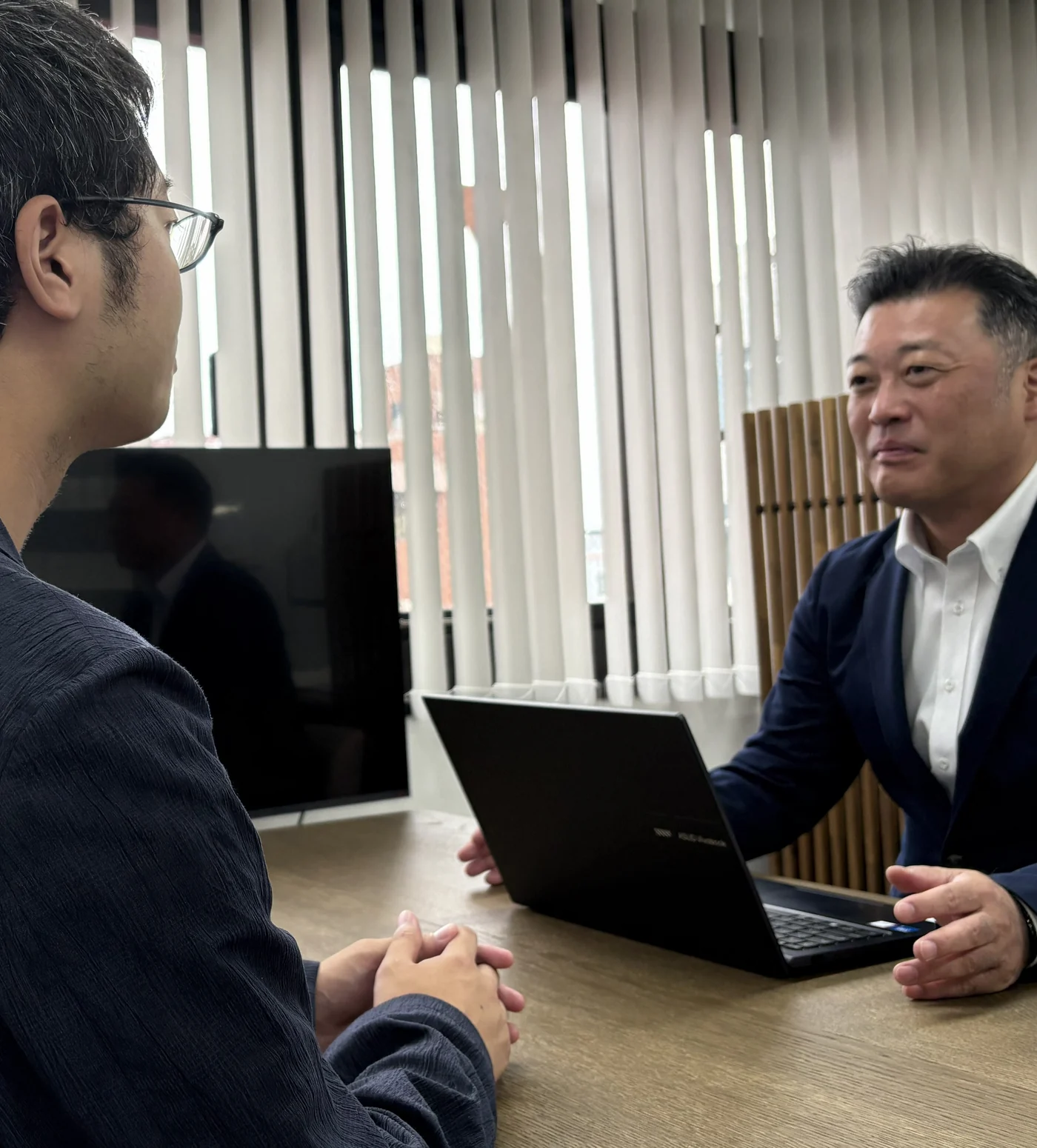植木克哉税理士が事務所で相談者の話を聞いている様子